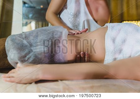 Woman having face massage treatment in wellness center.