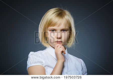 Closeup Thoughtful Young girl Looking Up with Hand on Face isolated on Gray Background.