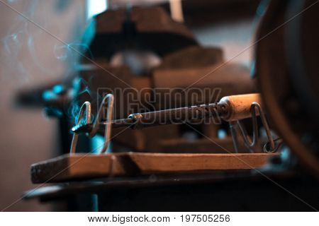 Old soldering iron in instrumental with blurred background