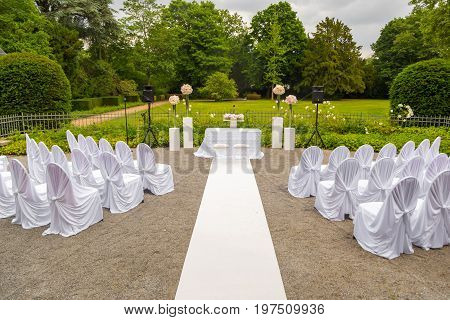 Scenery of the wedding ceremony in the park. White frame decorated with flowers. Ceremony in white style.