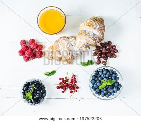 Croissant with fresh berry and juice for breakfast. Top view