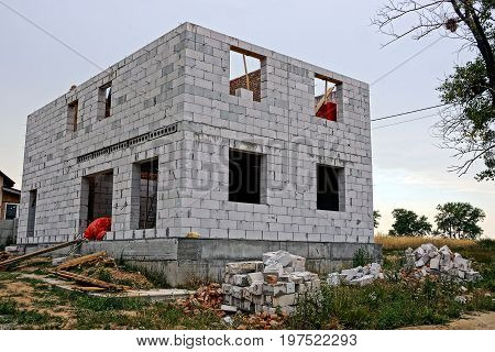 Construction site with unfinished house of white brick