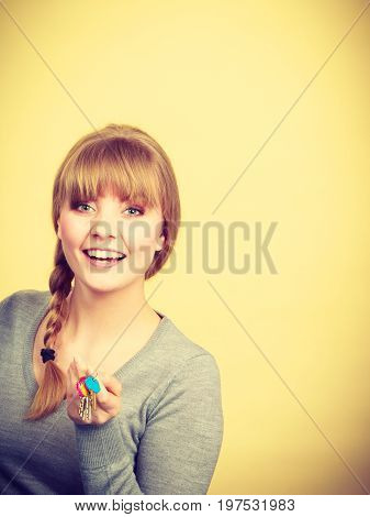 Ownership and property concept. Young blonde smiling female owner with bunch of colorful keys. Woman with key antry to her first own flat.