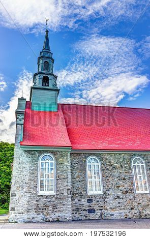 Ile D'Orleans Canada - June 1 2017: Saint-Jean red painted church with stone architecture and blue sky in summer