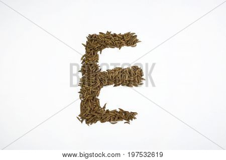 Written letters with carum carvi on white background