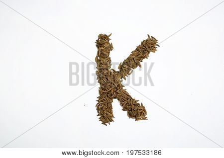 Written letters with carum carvi on white background