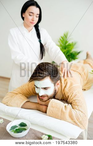 Man relaxing on massage table in spa salon