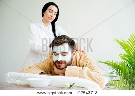Man relaxing on massage table in spa salon