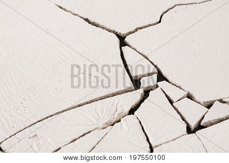 Fractured white concrete background. Old cracked plaster floor top view, copy space