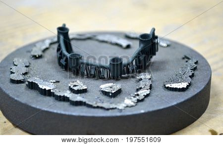 Object denture body printed on a laser sintering machine on the work disk close-up.