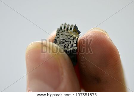 A man holds in his hand an object crown printed on a 3d printer that prints metal close-up