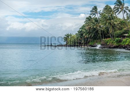 A lone fisherman tries his luck on a beach in the Kahan area of Maui Hawaii.
