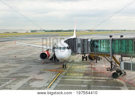 PRAGUE, CZECH REPUBLIC - JUNE 16, 2017: Aircraft with passage corridor or tunnel being prepared for departure from an international airport. Passengers boarding an airplane in a modern airport.