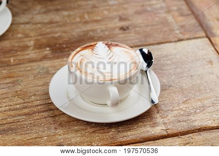 A cup of latte coffee top view on old wood background.