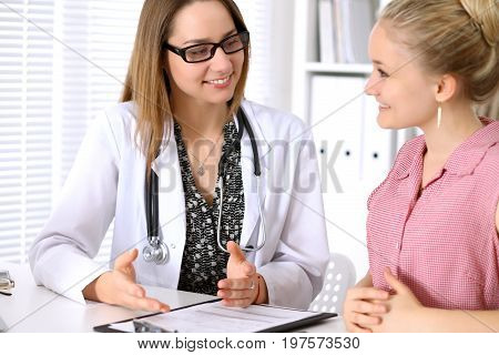 Doctor sitting near his patient and discussing confidental medical history.