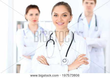 Happy female doctor with medical staff at the hospital. Successful team at health care concept