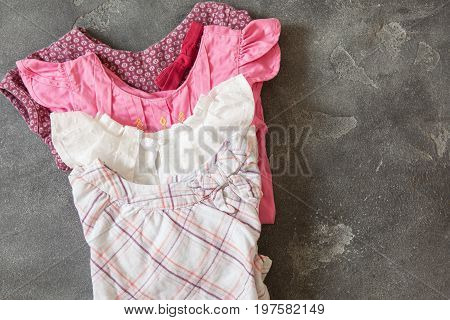 Stack Of Baby Girl Clothes In Pastel Color Range