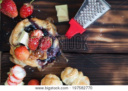 Blueberry cake decprated with fresh strawberry and white chocolate on the wooden background copy space