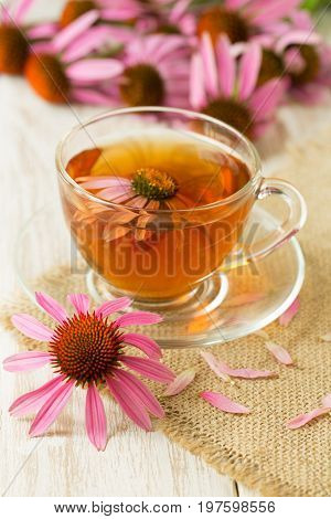 Cup of echinacea tea on white wooden table.