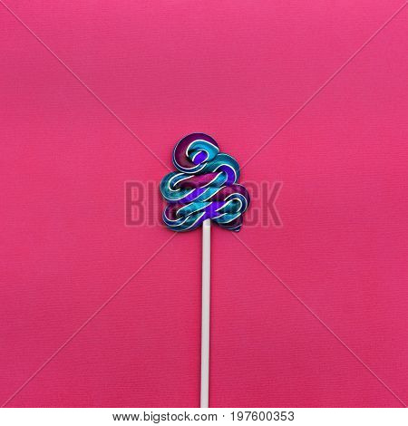 Lollipop Flat lay Minimal concept Multicolored lollipop on a pink background One spiral candy on a stick Trendy bright photo in modern pop art style Top view