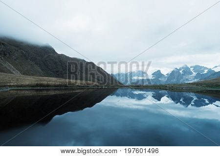 Beautiful mountain lake. Reflection of clouds in water. Lake Koruldi. Caucasus, Georgia, Zemo Svaneti