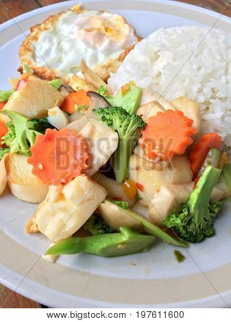 Mixed Fried Vegetable Tofu With Rice And Fried Egg In White Dish On Wooden Background. Vegetarian Fo