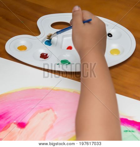 a little kid doing colorful painting square comp;osition