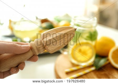 Female hand with juicer on light blurred background