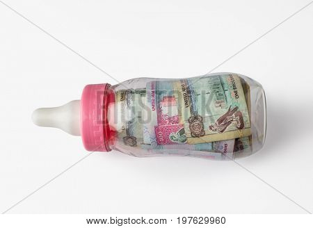 UAE dirham assorted notes in a feeding bottle. Stock image. 'Young economy' - creative concept.