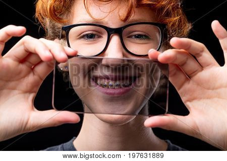 Smile Of A Girl In Braces Through A Transparent Mobile Phone