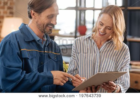 Right there, miss. Nice polite professional man asking client writing down her name on a document while needing the delivery confirmation