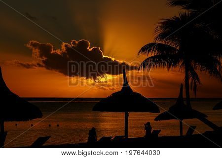 Sunset on a beach with silhouettes in the foreground