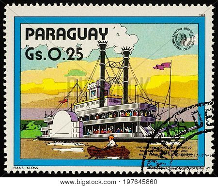 Moscow Russia - July 30 2017: A stamp printed in Paraguay shows old Mississippi steamboat - a scene from Adventures of Tom Sawyer by Mark Twain series 