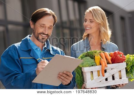 Scrupulous guy. Handsome attentive hardworking guy looking through the list for making sure everything being delivered and nothing missing
