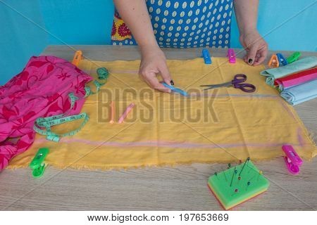 closeup of woman hands sewing yellow cloth outdoors. Woman's Hand Sewing Quilt