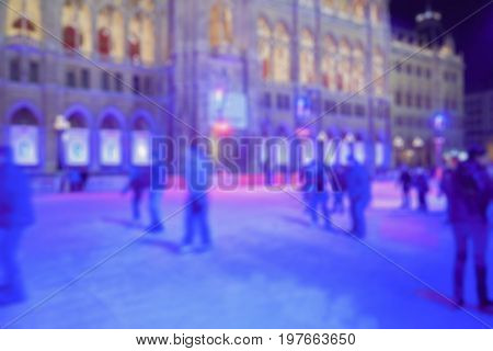 abstract blurred: people skate on the ice in the night city Europe