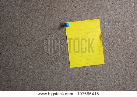 close up of a note paper with push pin on wood background.Business supplies