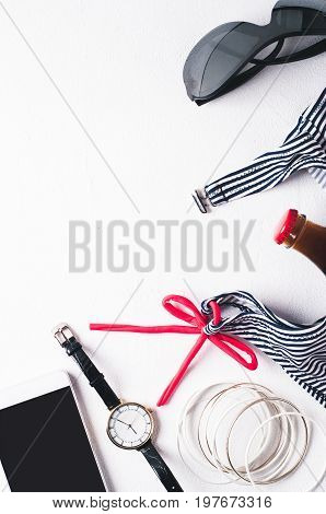 Retro Style Striped Swimsuit And Fashion Accessories  On A White Concrete Background