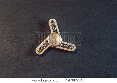 Famous Fidget Spinner Stress Relieving N A Black Wooden Background