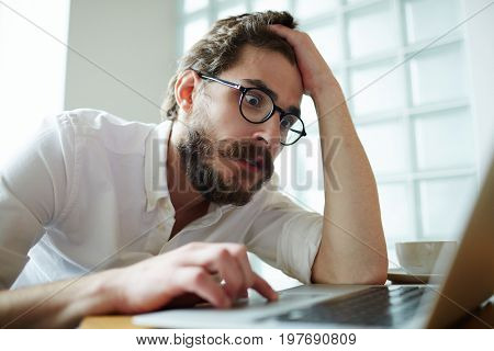 Nervous job-seeker sitting in front of laptop