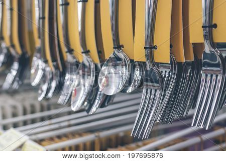 Stainless spoons and fork set hanging in the store. Shopping mall, Bali island.