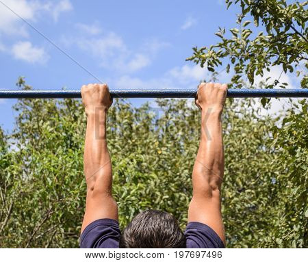 Hands On The Bar Close-up. The Man Pulls Himself Up On The Bar. Playing Sports In The Fresh Air. Hor