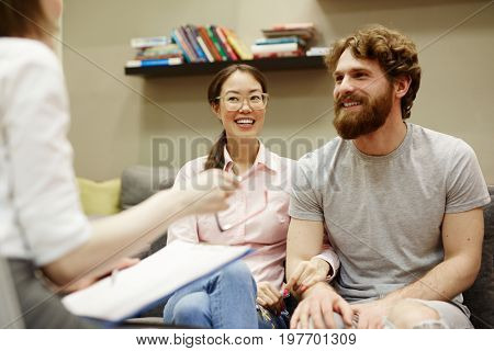Portrait of smiling young couple visiting advisor for family consultation