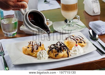 Eclairs with the dark hot chocolate and beze