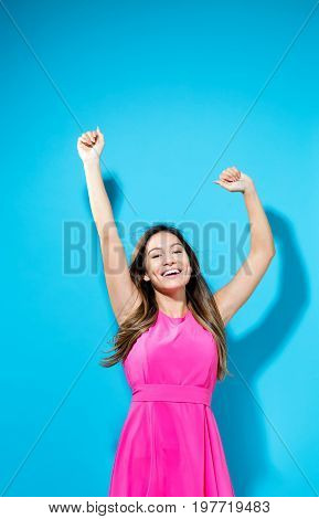 Happy woman with her arms outstreched on a blue background