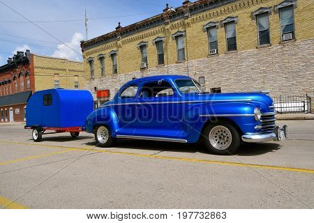 CASSELTON, NORTH DAKOTA, July 27, 2017: The annual Casselton Car Show which occurs the last Thursday of July features classic vehicles such as the 1948 Plymouth pulling a camper.