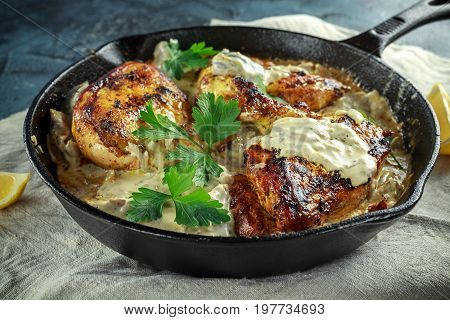 Creamy chicken fellets supremes in mushroom sauce with parsley In rustic cast iron skillet