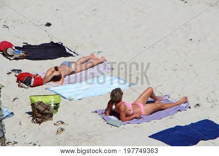 LANDUNVEZ - FRANCE MAY 26 : Two women in bikini sunbathing on the sand of a beach in Brittany, May 26, 2017