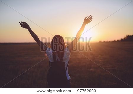Portrait Of Happy And Enjoying Young Woman On A Meadow On A Sunset. Cheerful Girl On Sunset. Lifesty