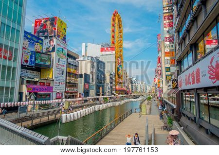 OSAKA, JAPAN - JULY 18, 2017: Unidentified people walking around of Dotonbori district surrounding of sign advertisements at Numba area, in a cloudy day in Osaka City, Japan.